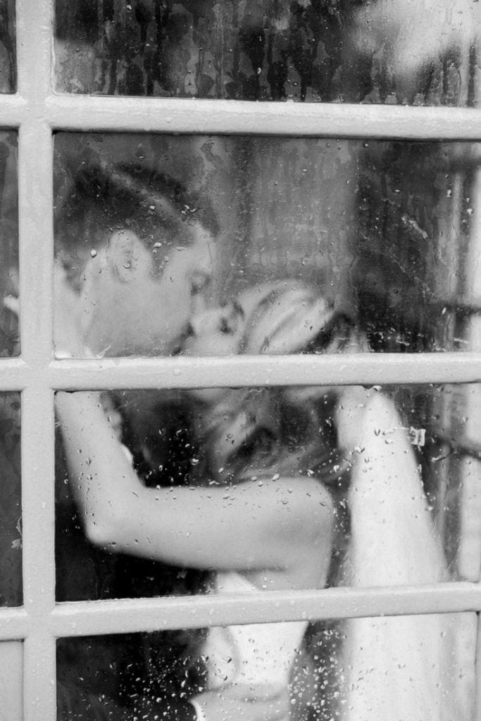 photography of a couple in a phone booth in Arizona in the rain