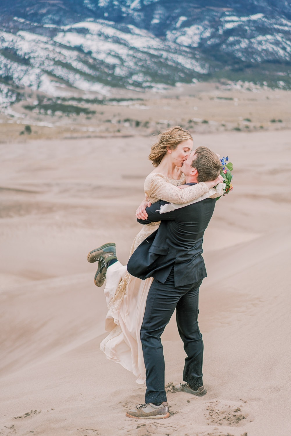 couple kissing during their elopement in the sand dunes of Colorado