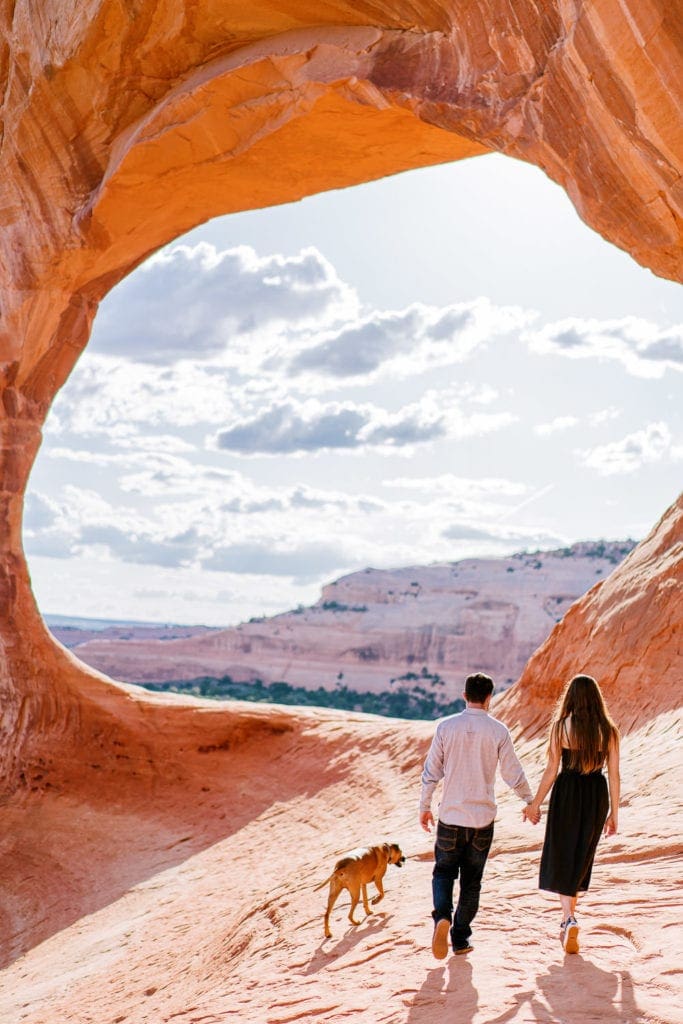 Moab engagement session with a dog under an arch