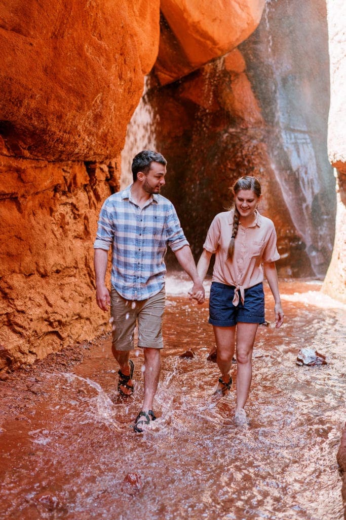 adventure engagement session in Moab, Utah in a canyon with a waterfall