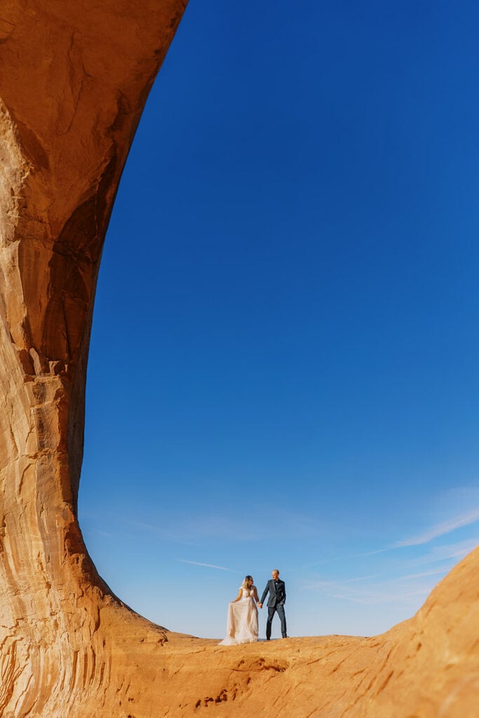 Bride and groom get married under an arch in Moab, Utah.