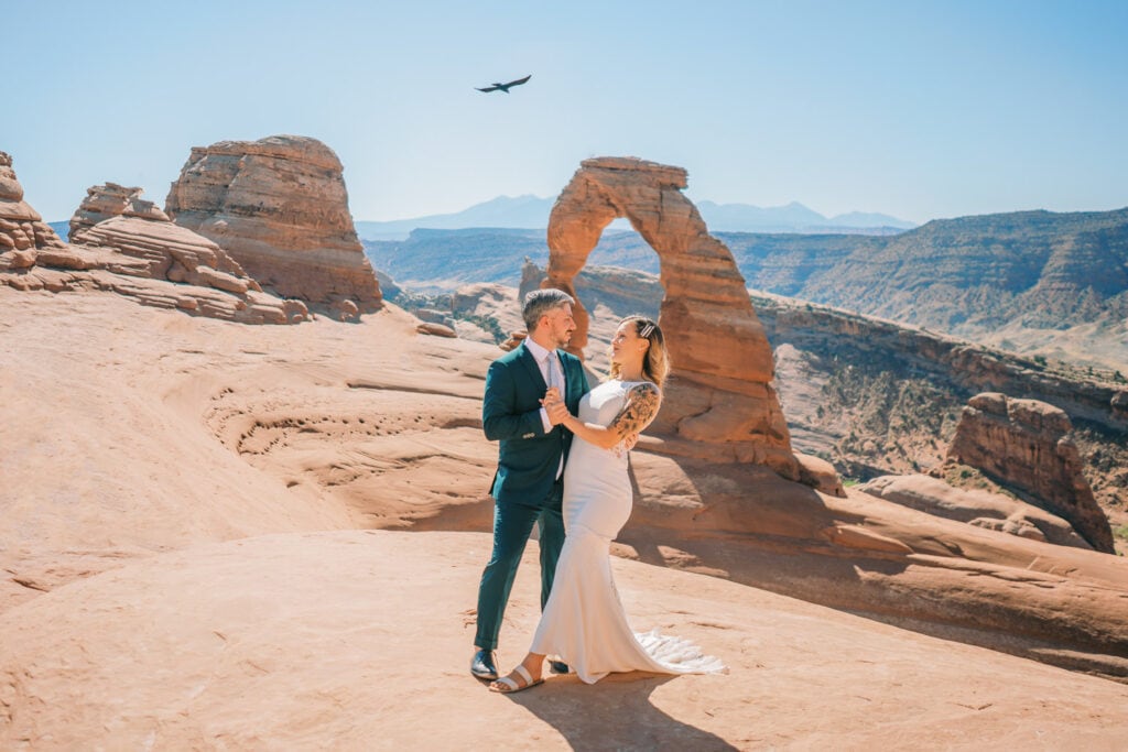 Moab elopement photographer with a bride and groom in Arches National Park near Delicate Arch in summer.