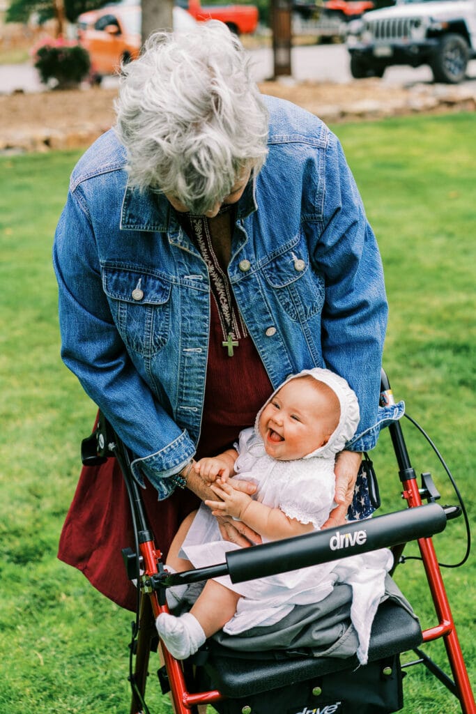 Grandma holds a baby at an outdoor wedding in Colorado.