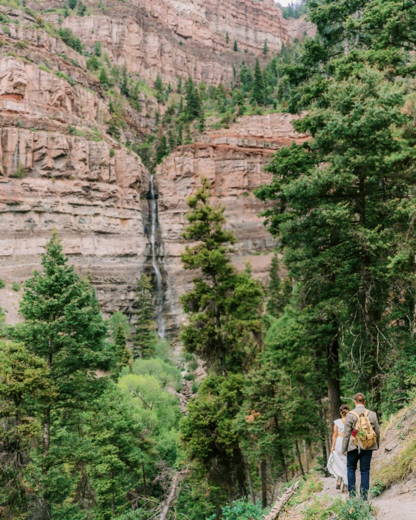 Bride and groom hike to Cascade Falls in Ouray, Colorado.