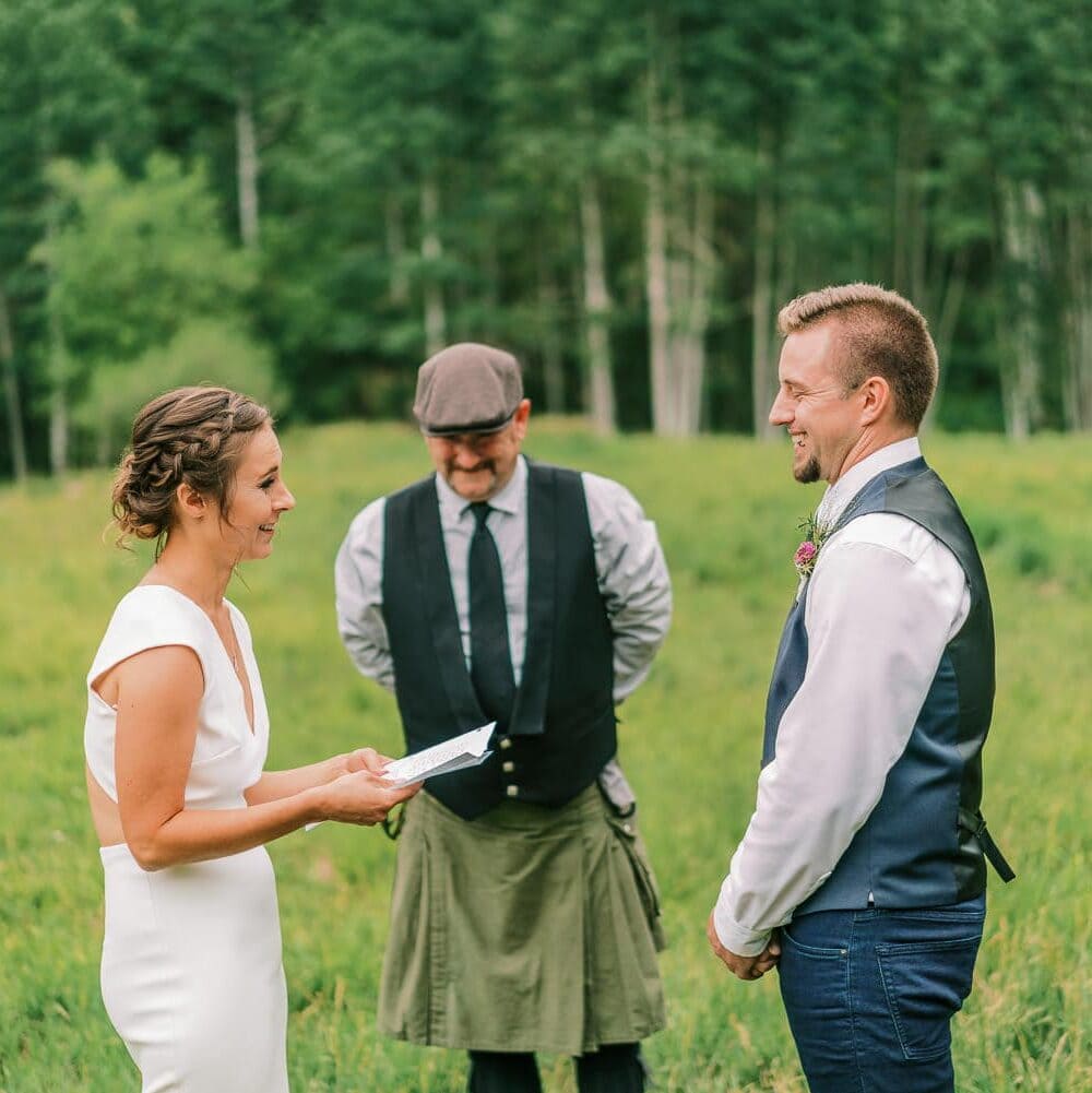 Bride says vows to her groom at an outdoor wedding in Colorado.