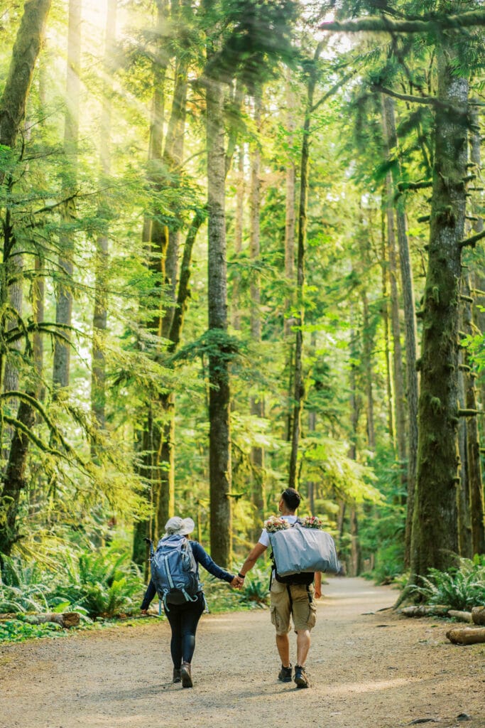 Bride and groom hiking together in the Hoh Rain Forest in Olympic National Park.