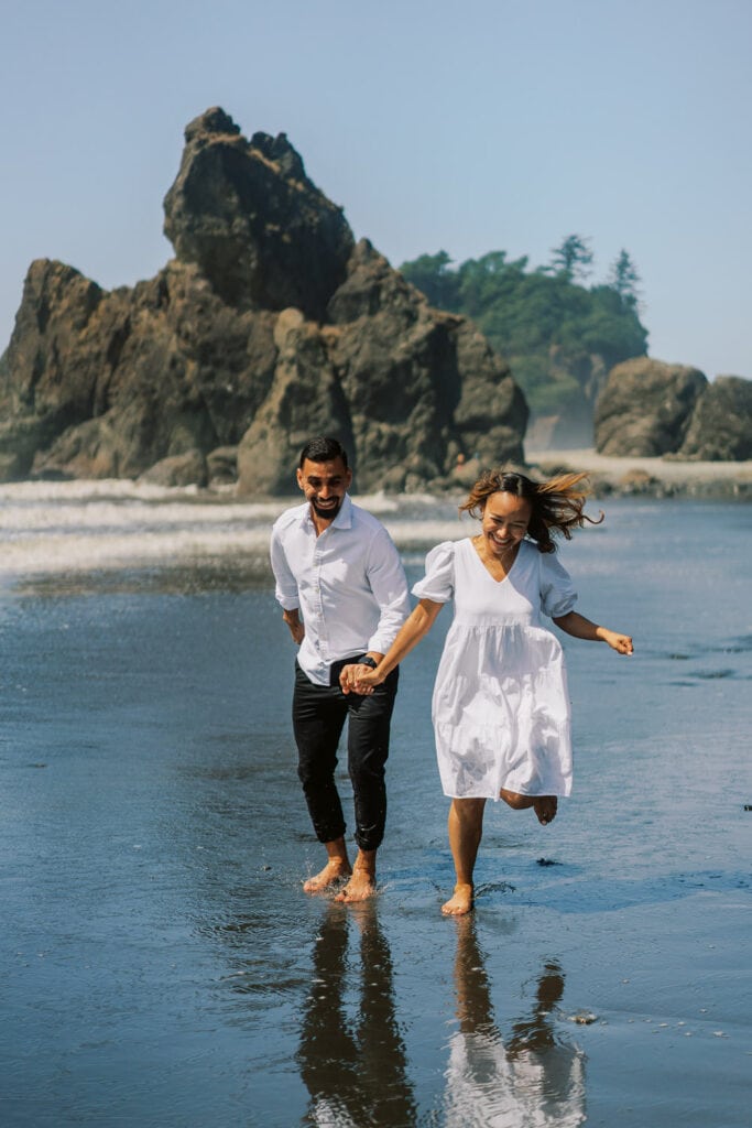 Bride and groom running along Ruby Beach for their elopement in Olympic National Park in Washington.