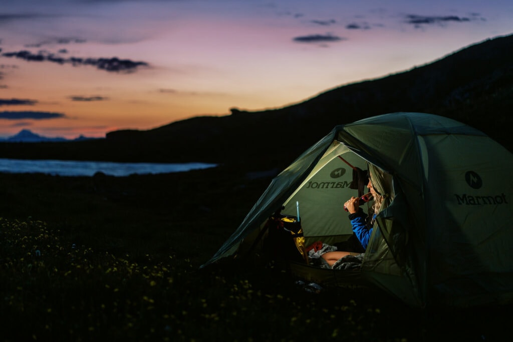 Bride gets ready in a tent just before sunrise at her 2 day backpacking elopement.