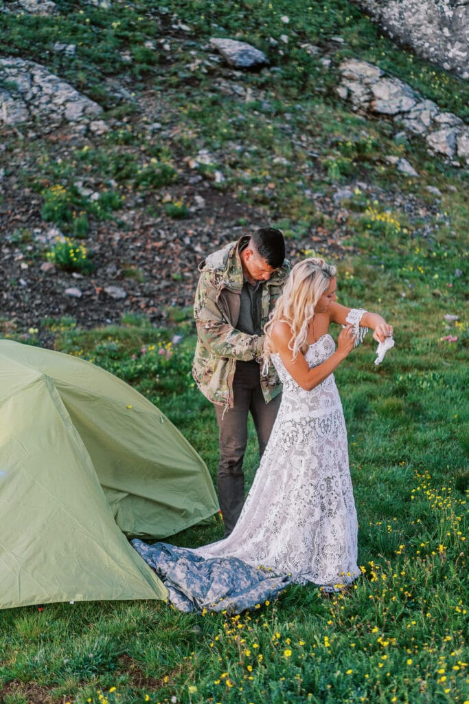 Bride and groom get ready outside a tent for an elopement in Colorado.