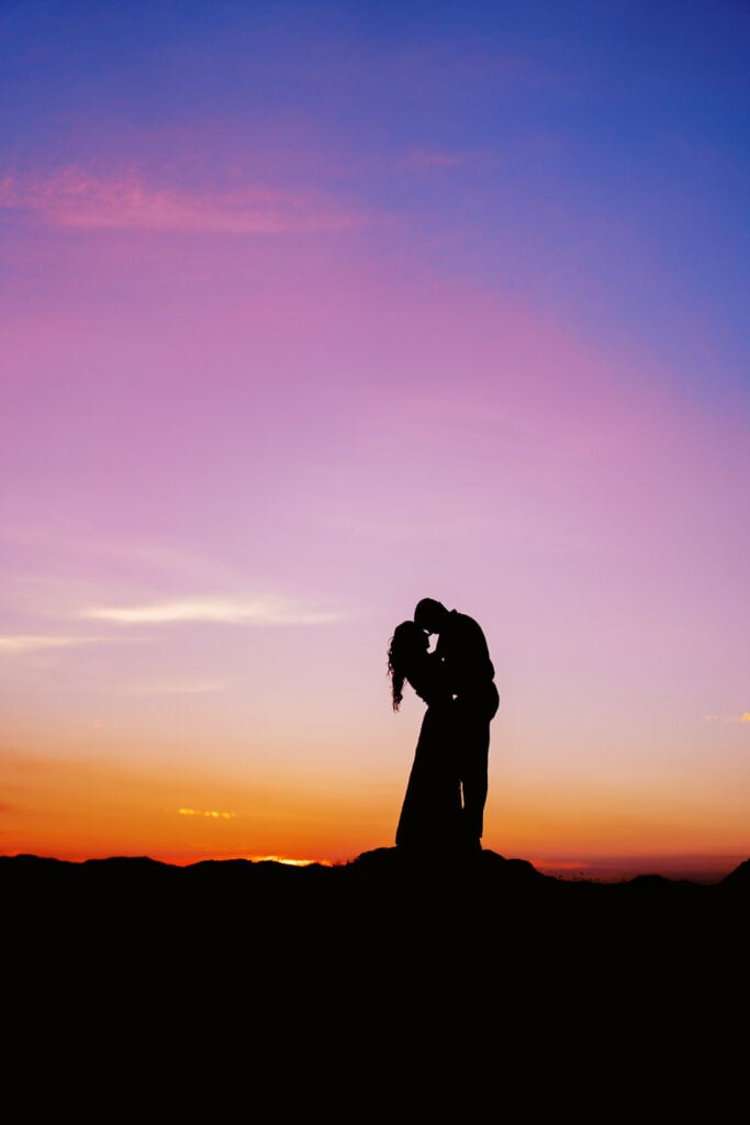 Silhouette photography of a bride and groom at sunrise.
