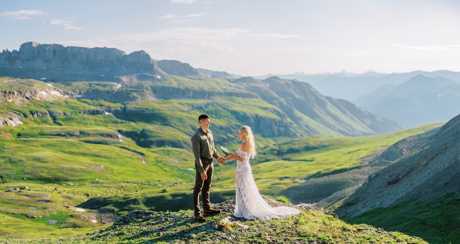 Bride and groom have an elopement ceremony in Colorado in the mountains during summer.