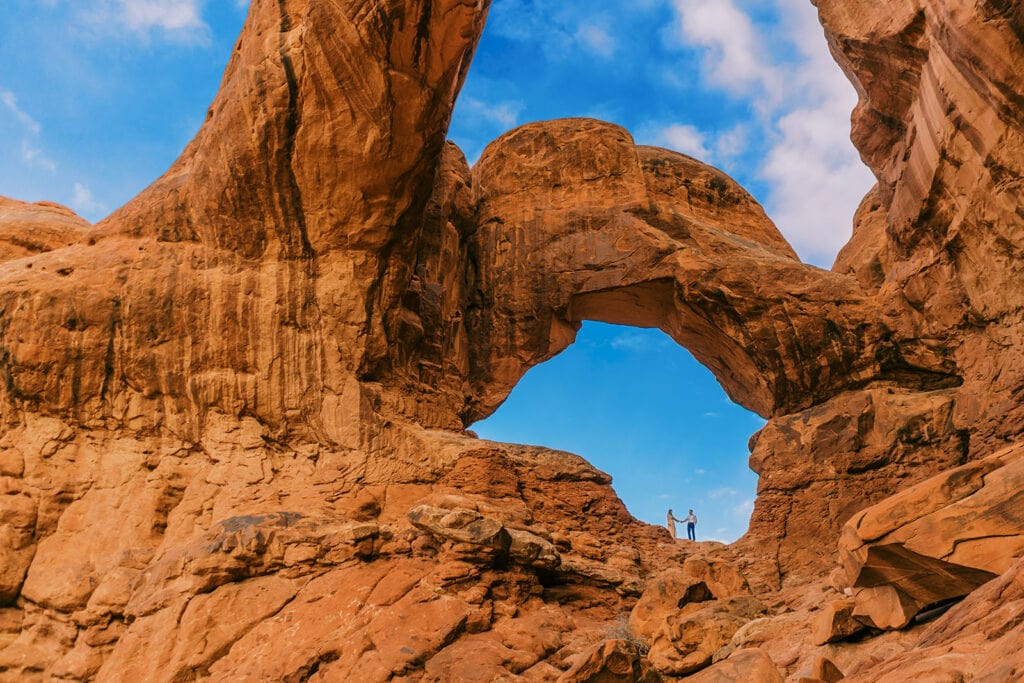 Couple under Double Arches in Arches National Park during their elopement.