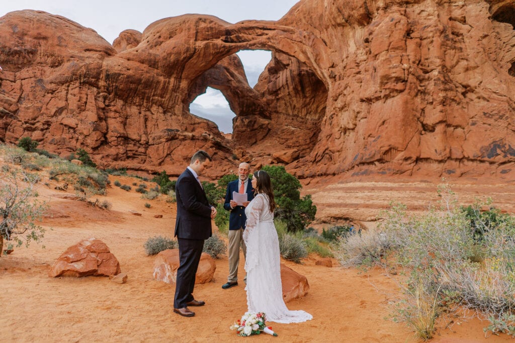 Bride and groom have an elopement ceremony at Double Arch in Arches National Park.