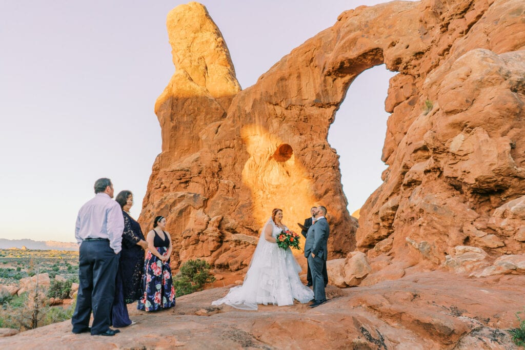 Elopement ceremony at Turret Arch at sunrise in Arches National Park.