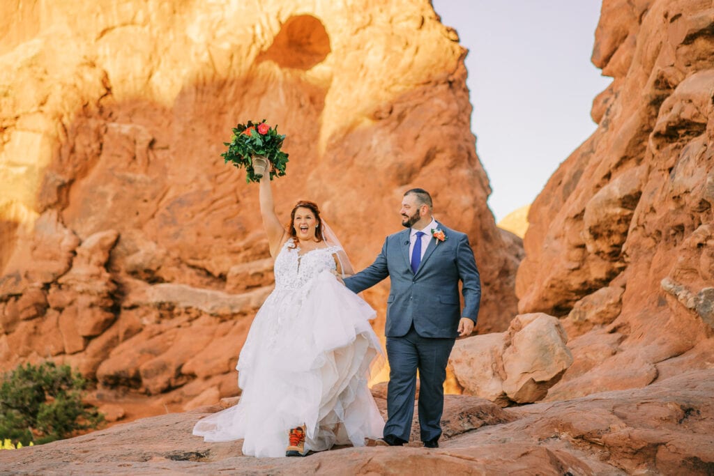 Couple celebrates after their elopement ceremony in Arches National Park at Turret Arch.
