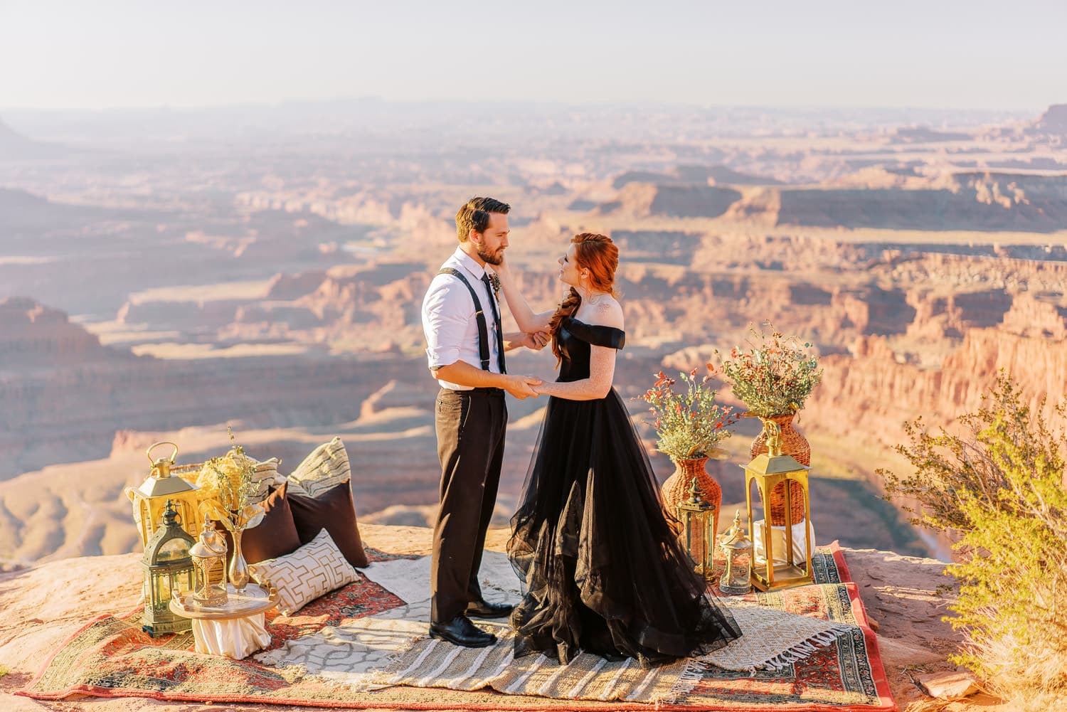 Bride in a black dress listens to vows during an elopement in Dead Horse Point State Park.
