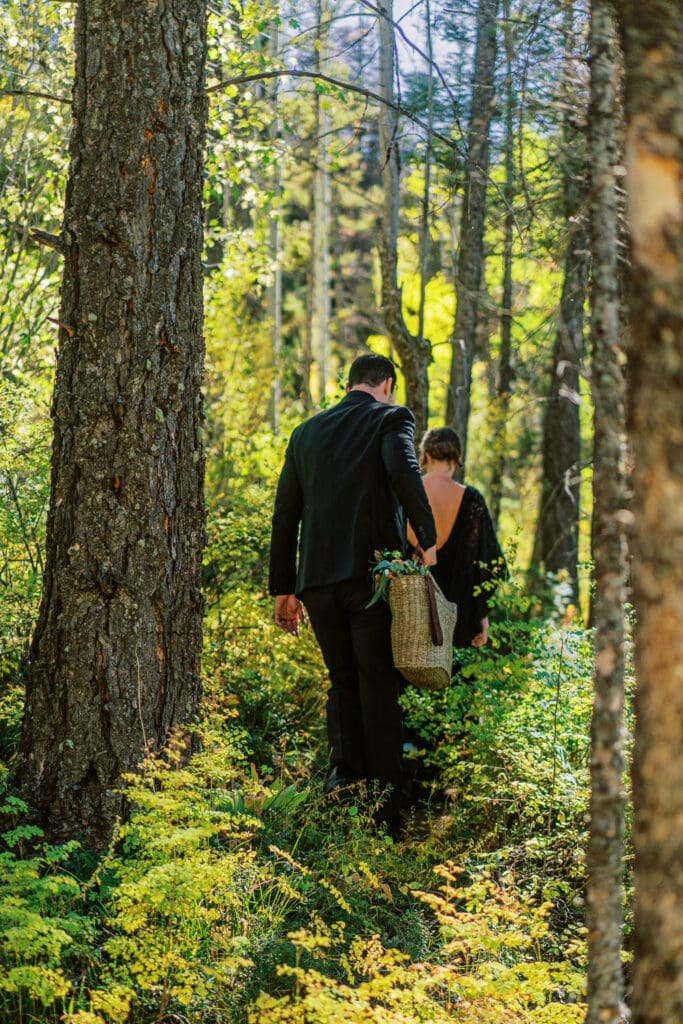 Bride and groom hiking together in the forests of Colorado.