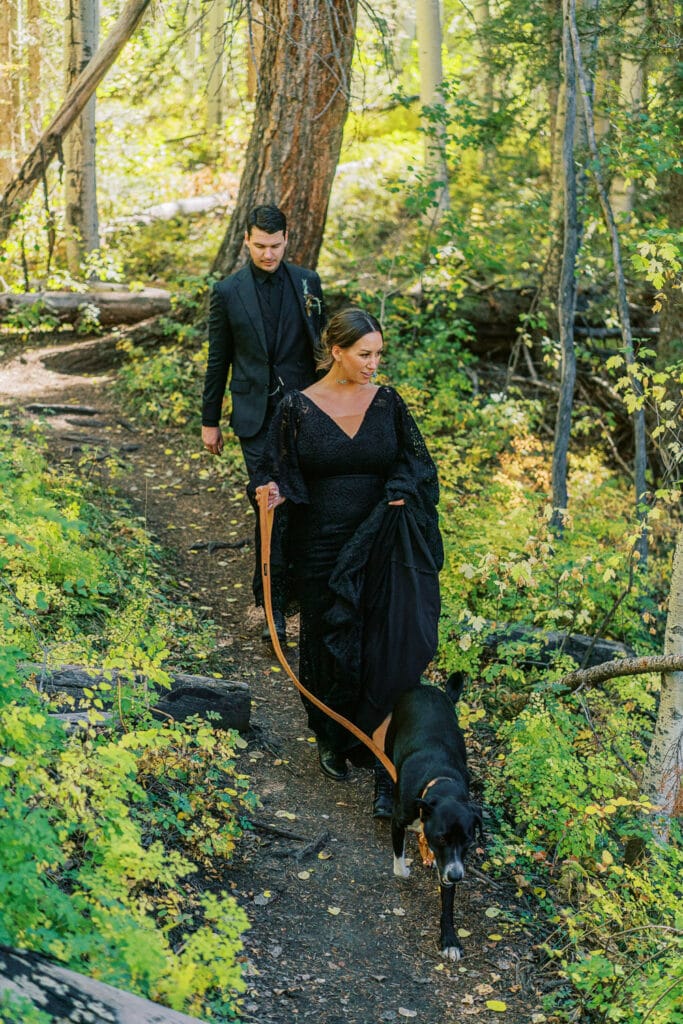 Bride and groom hiking back from a waterfall at their elopement in the mountains.