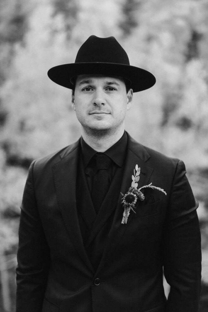 Black and white portrait of a groom in a Stetson hat.