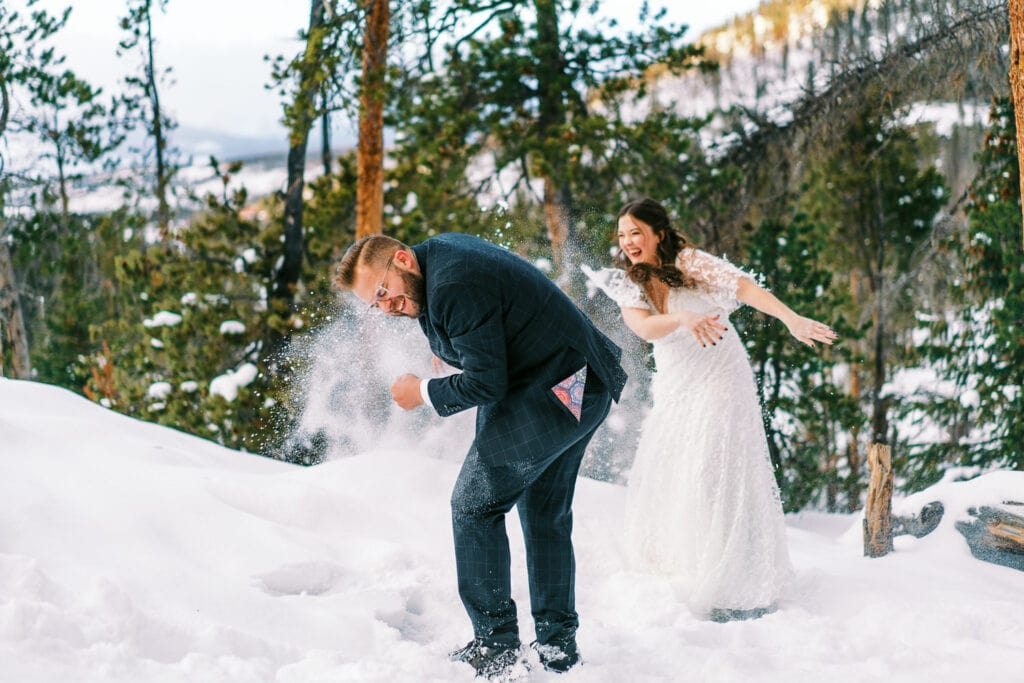 Bride and groom have a snowball fight during their wedding in Grand Lake, Colorado.