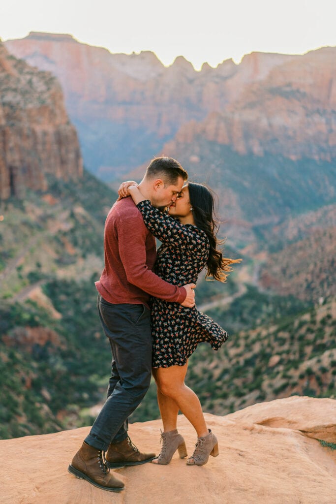 Couple kissing at a canyon overlook in Zion National Park in Utah.
