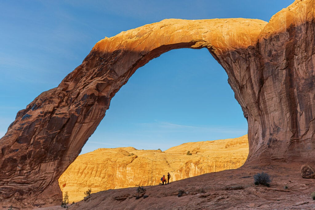 A man proposes to his girlfriend under an arch in Moab, utah.