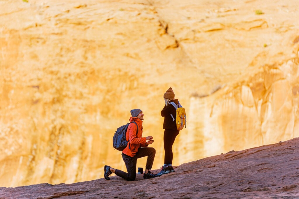 A man proposes to his girlfriend under an arch in Moab, Utah.