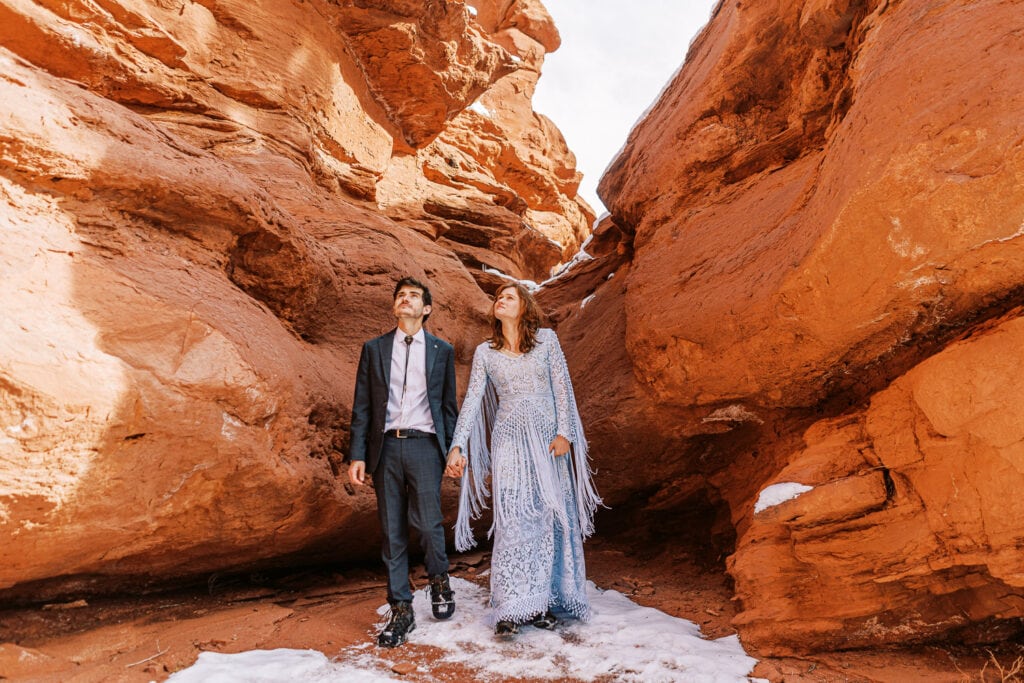 Couple hiking through a slot canyon for their elopement in Moab, Utah.