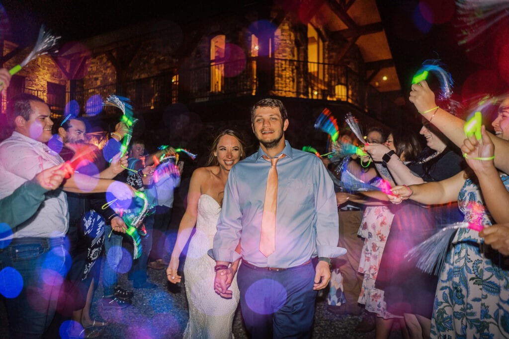 Post elopement reception with guests waving glow sticks as the couple exits their party.