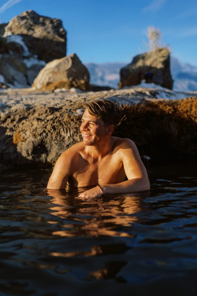 Malachi Lewis sitting in a hot spring in California.