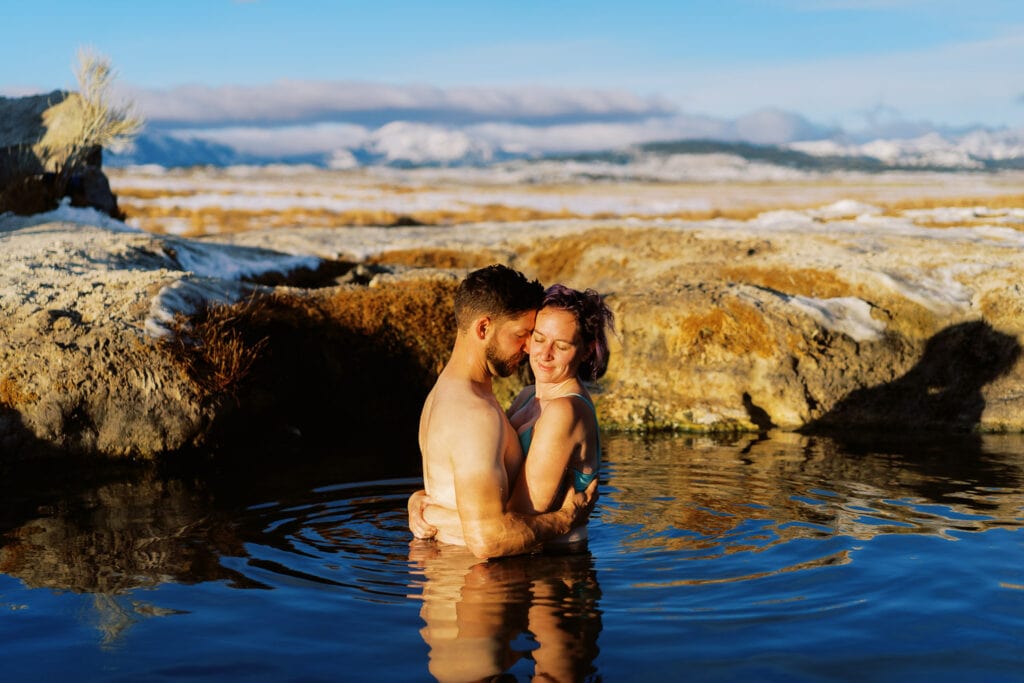 Couple relaxes in a natural hot spring near Bend, Oregon after their elopement day.