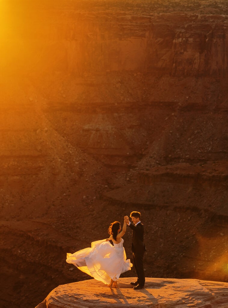 Bride and groom dance in the deserts of Utah during their Moab adventure elopement at sunset.
