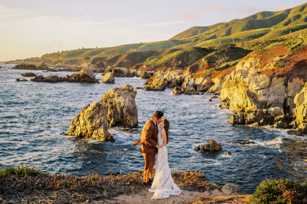 Couple kissing at sunset during their elopement on the coast in Big Sur, California.