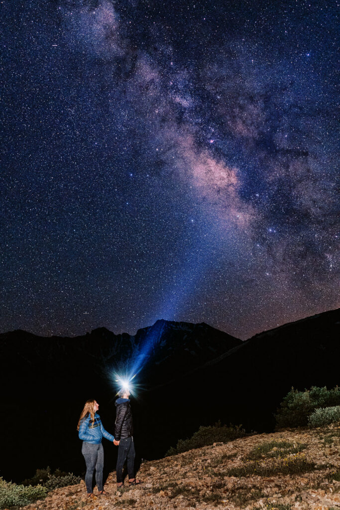 Couple looks up at the night sky in western Colorado during their engagement session.